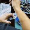 Tekniker, der tester et køretøjsspecifikt digitalt instrumentpanel på en testbænk i forbindelse med en garantikontrol